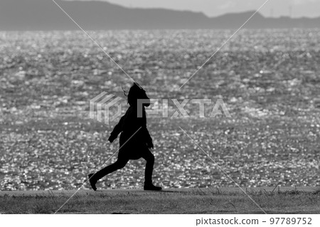 silhouette of people walking on the beach silhouette of people walking on the beach 97789752