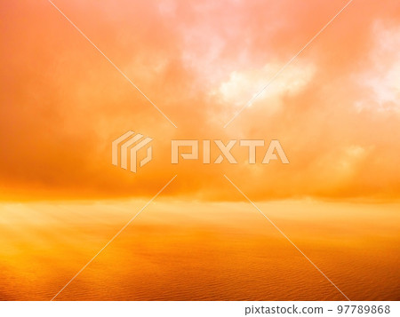 Aerial view red burning sunset over the sea with rocky volcanic cliff. Abstract nature summer sunset ocean sea background. Small waves on golden warm water surface Evening. Horizon. Nobody. No people. 97789868