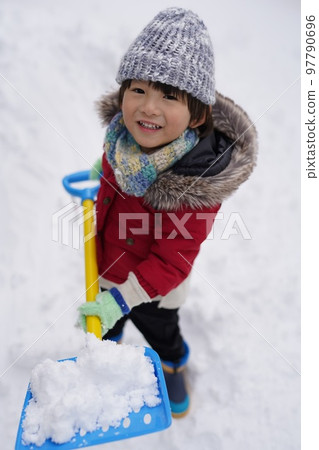 Boy playing in the snow and having fun Boy playing in the snow and having fun 97790696