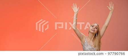 Girl dancing having fun standing fan-zone party enjoying awesome concert favorite singer in silver glittering elegant dress raise hands up waving palms moving music rhythm smiling delighted 97790766