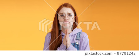 Please beg you. Clingy upset sad caucasian redhead girlfriend wearing glasses frowning grimacing pouting pleading help asking favour need urgently borrow something, orange background Please beg you. Clingy upset sad caucasian redhead girlfriend wearing glasses frowning grimacing pouting pleading help asking favour need urgently borrow something, orange background 97791242