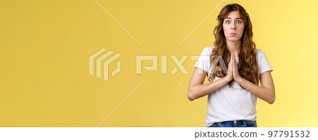 Pretty please beg you help me. Innocent cute lovely upset caucasian girl begging pleading your mercy pulling face hope for pity apologizing puppy eyes frowning need urgent advice yellow background 97791532