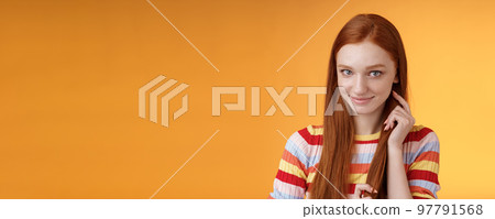 Romantic flirty shy attractive redhead girl 20s touching hair strand smiling silly modest glancing camera coquettish making lovely glances wanna seduce guy expressing sympathy, orange background Romantic flirty shy attractive redhead girl 20s touching hair strand smiling silly modest glancing camera coquettish making lovely glances wanna seduce guy expressing sympathy, orange background 97791568