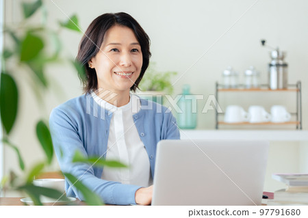 A middle-aged woman doing research on a computer 97791680
