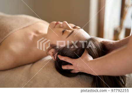 Woman receiving head massage at beauty salon 97792255