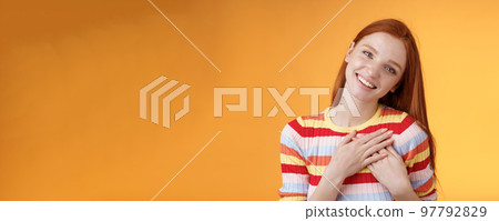 Happy grateful passionate stylish redhead european girl thanking dearest friend lovely sweet gift press palms heart smiling broadly tilting head amused gratefully appreciate, orange background Happy grateful passionate stylish redhead european girl thanking dearest friend lovely sweet gift press palms heart smiling broadly tilting head amused gratefully appreciate, orange background 97792829