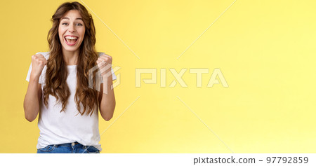 Yes finally success. Cheerful enthusiastic happy girl pump fists lift hands victory joy celebration gesture smiling broadly relieved winning lottery amused stand yellow background triumphing Yes finally success. Cheerful enthusiastic happy girl pump fists lift hands victory joy celebration gesture smiling broadly relieved winning lottery amused stand yellow background triumphing 97792859
