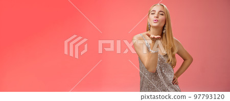 Flirty feminine carefree charming coquettish blond caucasian woman long hairstyle in silver dress hold hand fold lips send air kiss camera close eyes give passionate lovely mwah, red background Flirty feminine carefree charming coquettish blond caucasian woman long hairstyle in silver dress hold hand fold lips send air kiss camera close eyes give passionate lovely mwah, red background 97793120