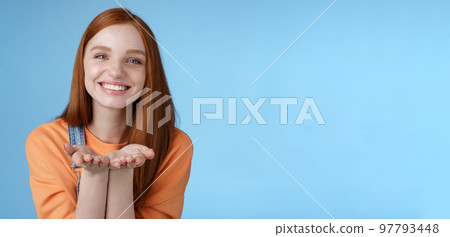 Cute tender kind young ginger girl giving all love you, hold something palms showing camera smiling delighted introduce present grinning romantic gesture send air kisses, blue background Cute tender kind young ginger girl giving all love you, hold something palms showing camera smiling delighted introduce present grinning romantic gesture send air kisses, blue background 97793448