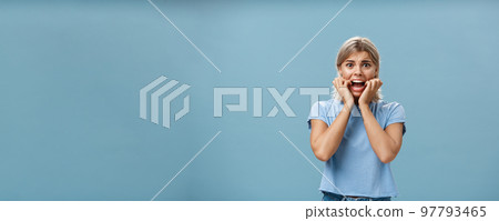 Indoor shot of shocked troubled girlfriend hearing mom returned home being with boyfriend biting fingernails being in helpless perplexed situation feeling anxious and scared over blue background Indoor shot of shocked troubled girlfriend hearing mom returned home being with boyfriend biting fingernails being in helpless perplexed situation feeling anxious and scared over blue background 97793465