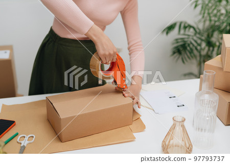Small business owners are packing cardboard boxes at work. Small business owners are packing cardboard boxes at work. 97793737