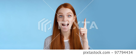 Excited good-looking cheerful ginger girlfriend add idea conversation raise index finger eureka gesture open mouth wide tell suggestion smiling broadly pondering excellent variant, blue background Excited good-looking cheerful ginger girlfriend add idea conversation raise index finger eureka gesture open mouth wide tell suggestion smiling broadly pondering excellent variant, blue background 97794434