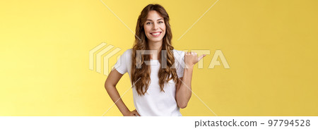 Friendly outgoing cheerful european cute female giving tips showing direction lively smiling toothy happily have nice pleasant conversation pointing left thumb introduce promo yellow background 97794528