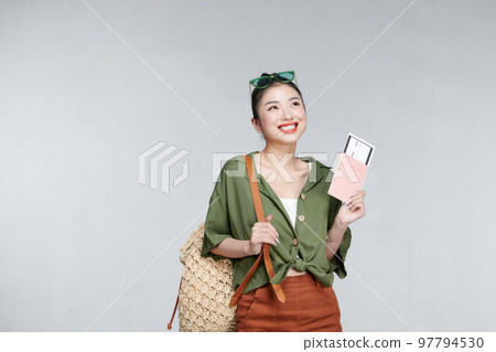 Portrait beautiful young asian woman with backpack travel bag with passport and boarding pass ticket on gray background Portrait beautiful young asian woman with backpack travel bag with passport and boarding pass ticket on gray background 97794530