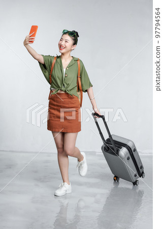 Full length traveler tourist woman hold suitcase do selfie on mobile cell phone 97794564