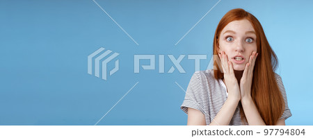 Shit bummer. Shocked worried young intense serious-looking confused young redhead girl look stressed nervously touching face wide eyes staring camera anxiously, standing blue background 97794804