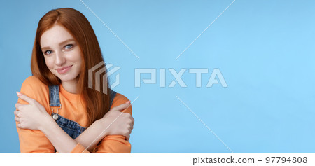 Romantic sensitive flirty young redhead girlfriend feel warmth embraces hugging herself hands crossed body tilting head smiling safe gentle, dreaming lovely date recalling sensual moments 97794808
