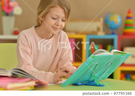 little girl doing homework at the table at home little girl doing homework at the table at home 97795166