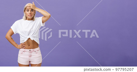 Damn I am in trouble. Worried troubled good-looking stylish female employee with tanned skin and fit body holding hand on forehead popping eyes from anxiety and making nervous face over purple wall Damn I am in trouble. Worried troubled good-looking stylish female employee with tanned skin and fit body holding hand on forehead popping eyes from anxiety and making nervous face over purple wall 97795207