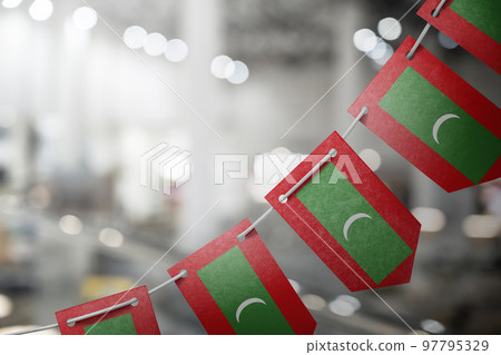 A garland of Maldives national flags on an abstract blurred background 97795329