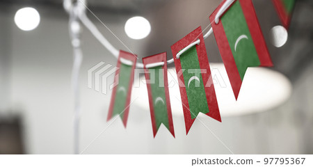 A garland of Maldives national flags on an abstract blurred background 97795367