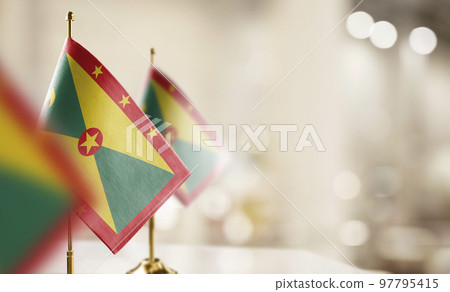 Small flags of the Grenada on an abstract blurry background 97795415