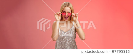 Sassy carefree daring young blond girl winking cheeky smiling assertive making first move approach handsome man nightclub asking dance standing red background touching sunglasses wear dress Sassy carefree daring young blond girl winking cheeky smiling assertive making first move approach handsome man nightclub asking dance standing red background touching sunglasses wear dress 97795515