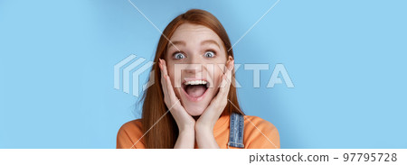 Impressed excited overwhelmed young redhead girlfriend fan screaming thrilled express afection adore awesome music band yelling happily reacting surprised astonished, standing blue background 97795728