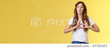 Passionate feminine sensual attractive girl curly hairstyle folding lips kiss blow muah camera express sympathy confess love show heart gesture you passionate cherish relationship romance in air 97795972