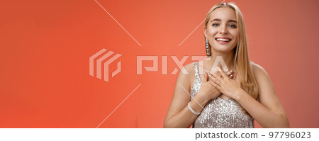 Grateful charming blond european 25s woman in silver party dress press palms heart feel thankful appreciate effort cherish romantic gesture receive flattering compliments gifts, smiling happily Grateful charming blond european 25s woman in silver party dress press palms heart feel thankful appreciate effort cherish romantic gesture receive flattering compliments gifts, smiling happily 97796023