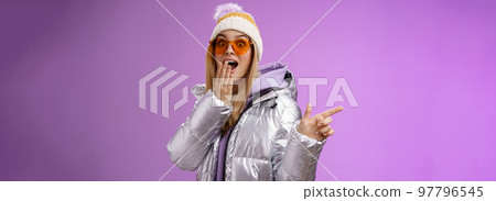 Amazed speechless surprised attractive stylish blond girlfriend in sunglasses, silver glittering jacket hat drop jaw impressed widen eyes shocked pointing left astonished, purple background Amazed speechless surprised attractive stylish blond girlfriend in sunglasses, silver glittering jacket hat drop jaw impressed widen eyes shocked pointing left astonished, purple background 97796545