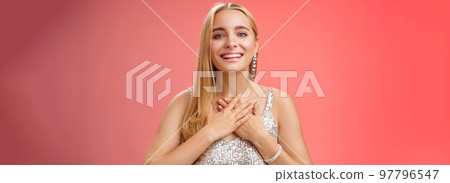 Grateful charming blond european 25s woman in silver party dress press palms heart feel thankful appreciate effort cherish romantic gesture receive flattering compliments gifts, smiling happily Grateful charming blond european 25s woman in silver party dress press palms heart feel thankful appreciate effort cherish romantic gesture receive flattering compliments gifts, smiling happily 97796547