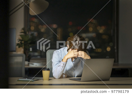 晚上在辦公室裡抱著頭的女商人 97798179