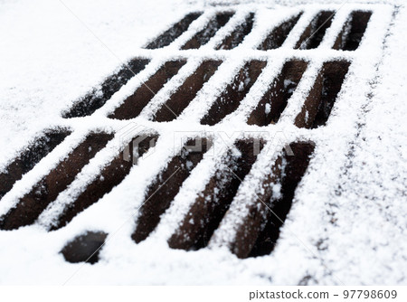 Drain grate covered with snow. Drain grate covered with snow. 97798609