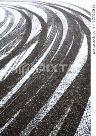 Wheel tracks on the road covered with snow Wheel tracks on the road covered with snow 97798615