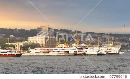 European coast of the Bosporus strait with docked ferry boats, and Dolmabahce Palace in the background, Istanbul, Turkey 97799646