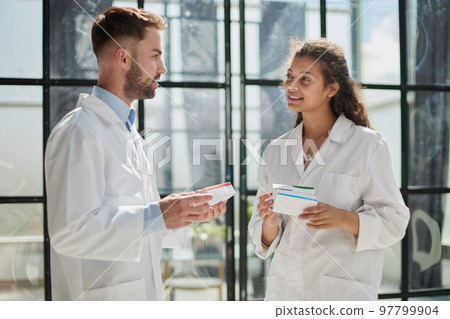 doctors holding pills in hand in hospital room 97799904