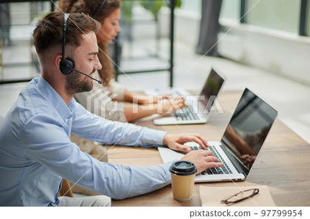 Customer Service Representative With Colleague Working In Office 97799954