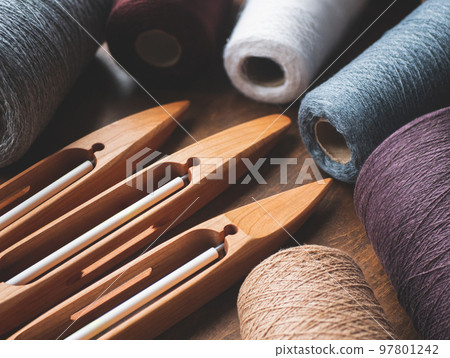 Three wooden boat shuttles with yarn in neutral tones. Preparation for hand weaving Three wooden boat shuttles with yarn in neutral tones. Preparation for hand weaving 97801242