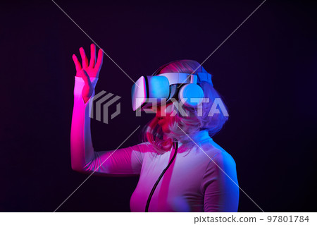 Woman in virtual reality goggle in neon colors. 97801784