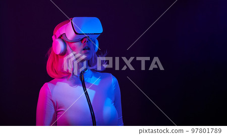 Woman in virtual reality goggle in neon colors. 97801789