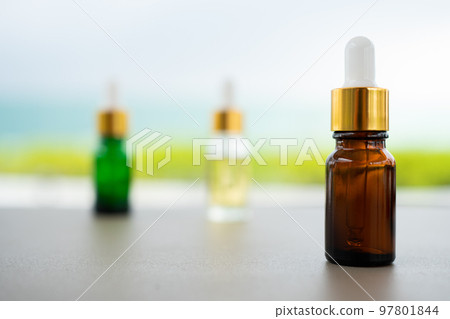 Set of multi color glass bottles with dropper on the table. Concept of aroma oil, cosmetic and beauty skin. Set of multi color glass bottles with dropper on the table. Concept of aroma oil, cosmetic and beauty skin. 97801844