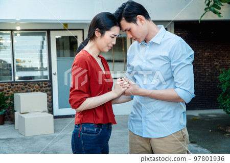 Man comforting his wife and woman hugging her husband and cry in front of the house and full of cardboard boxes during the transport in move out day, moving home concept Man comforting his wife and woman hugging her husband and cry in front of the house and full of cardboard boxes during the transport in move out day, moving home concept 97801936