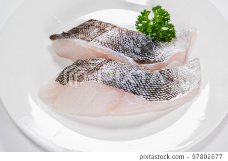 Cod fillet on a white plate 97802677