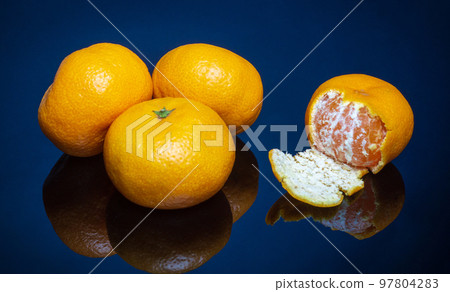 Ripe yellow tangerines or mandarins fruit on blue background. Idea clementines dieta Ripe yellow tangerines or mandarins fruit on blue background. Idea clementines dieta 97804283