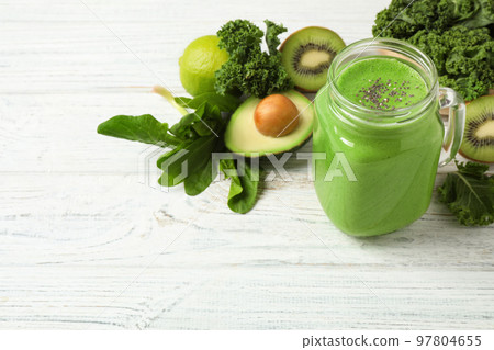 Tasty fresh kale smoothie on white wooden table Tasty fresh kale smoothie on white wooden table 97804655