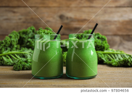 Tasty fresh kale smoothie on wooden table Tasty fresh kale smoothie on wooden table 97804656