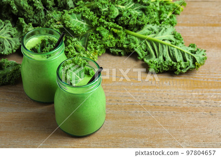 Tasty fresh kale smoothie on wooden table Tasty fresh kale smoothie on wooden table 97804657
