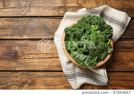 Fresh kale leaves on wooden table, top view. Space for text 97804667