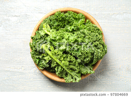 Fresh kale leaves on light grey wooden table, top view Fresh kale leaves on light grey wooden table, top view 97804669